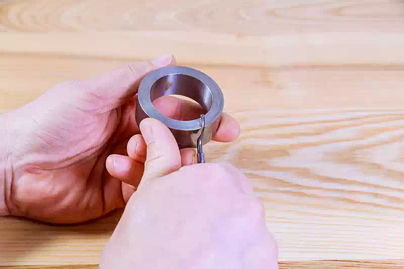 Mano che usa uno strumento per la sbavatura dei metalli.